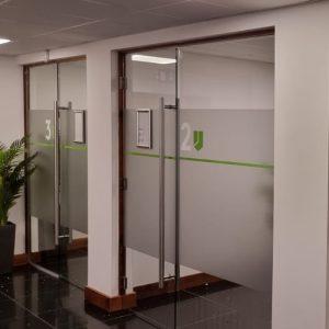 Interior of office corridor with glass doors leading to office rooms.
